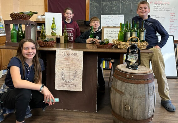 children posing with their business project of a winery